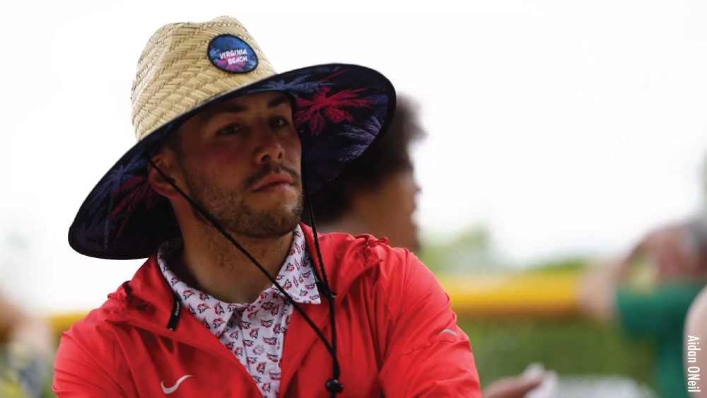 greg raimondi, track & field coach at carthage college in a red nike jacket and straw hat